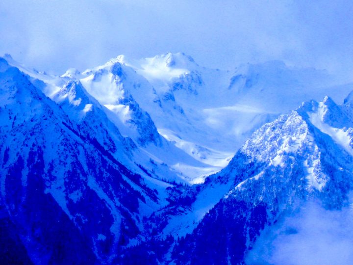 Distant blue mountains that are snow covered with haze.